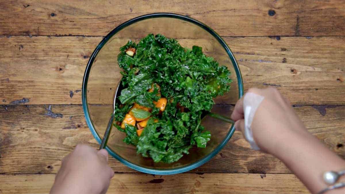 Mixing the salad ingredients in using spoon and fork.