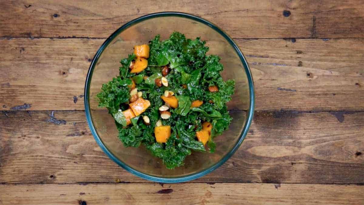 Mango Kale Salad with almonds and lemon dressing is ready to serve.