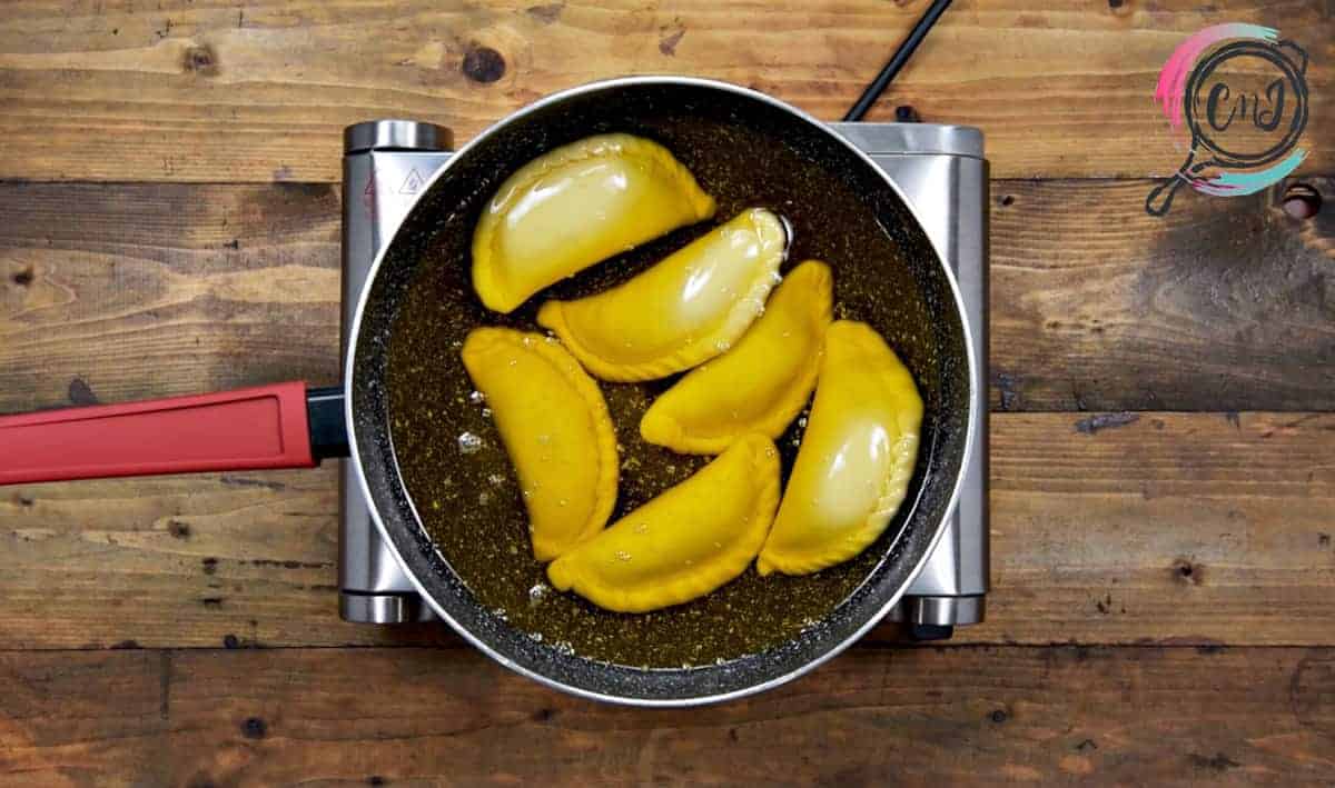 Ghujia frying in ghee in pan.