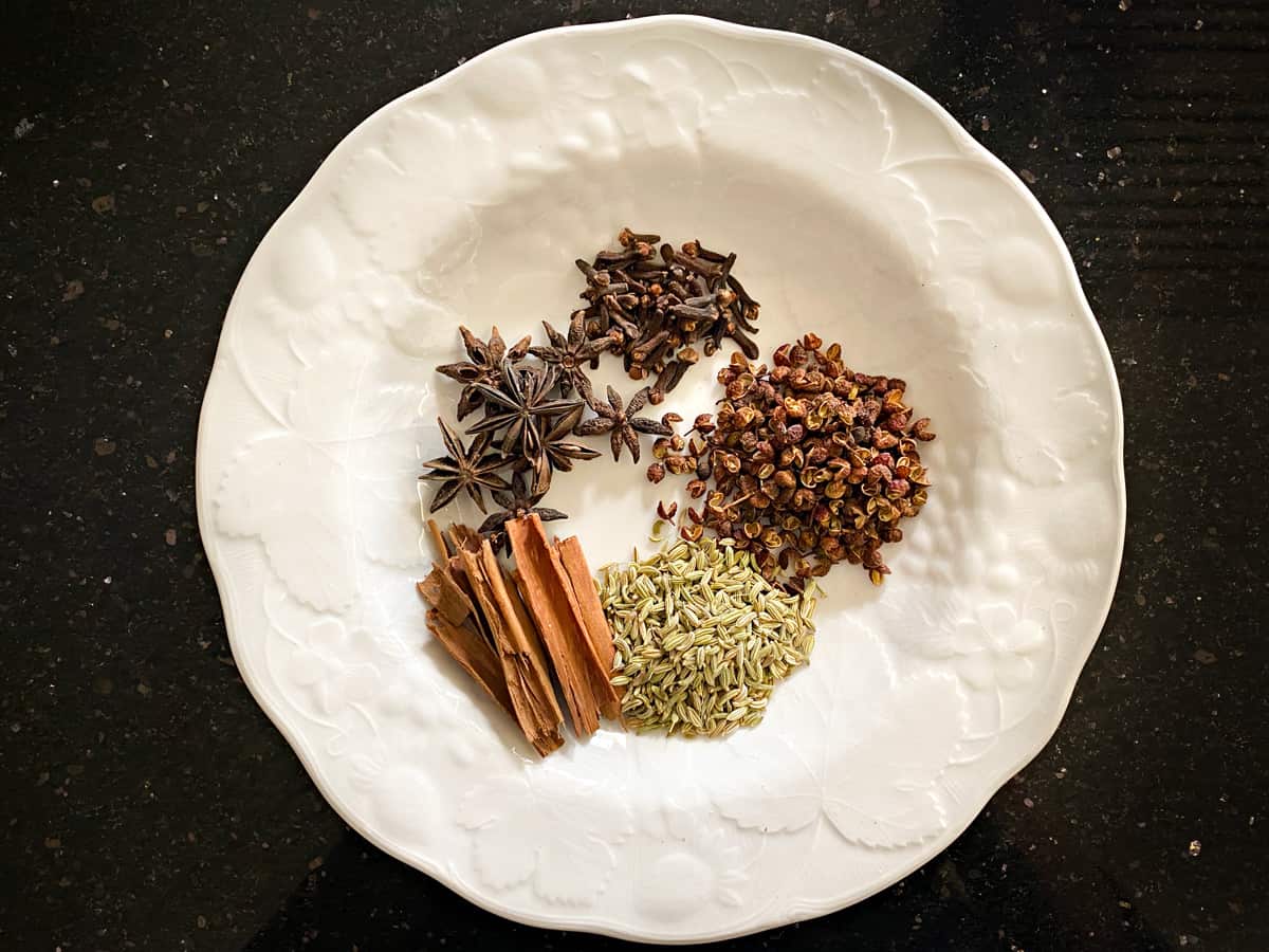 5 whole spices on white plate.