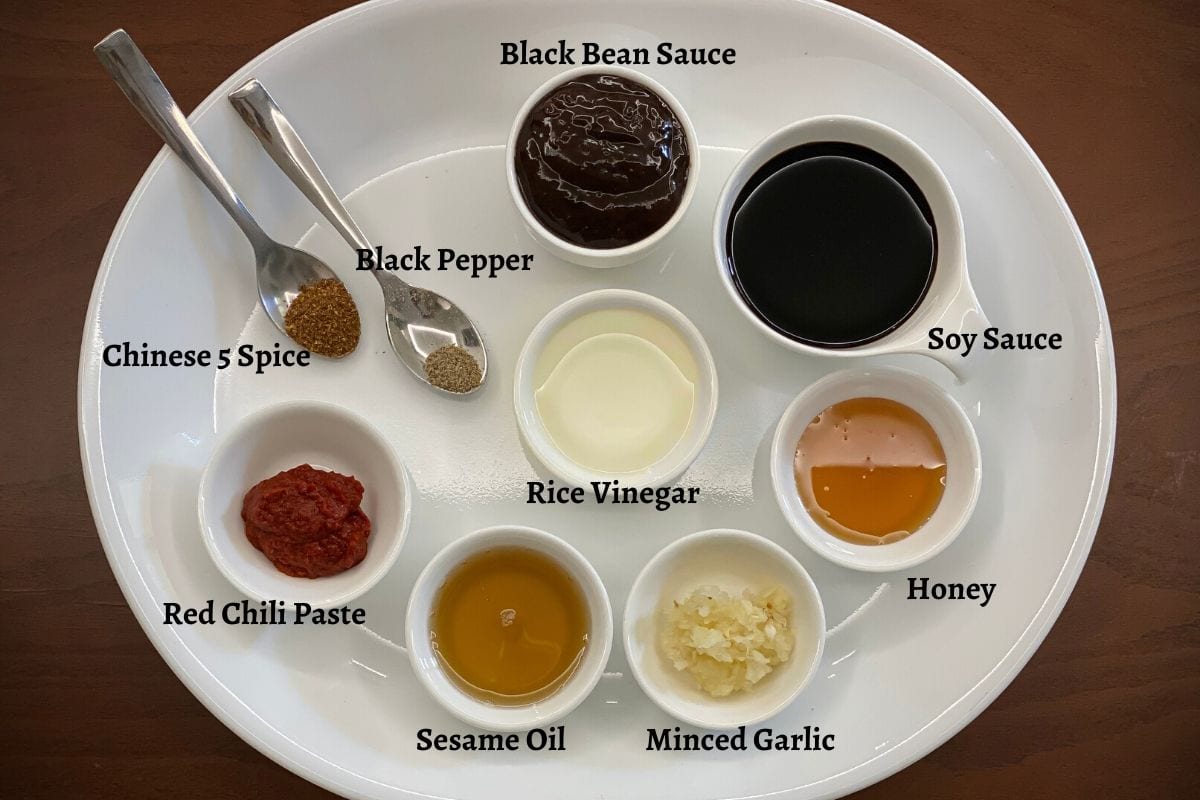 Hoisin sauce ingredients in small bowls placed on big white tray.
