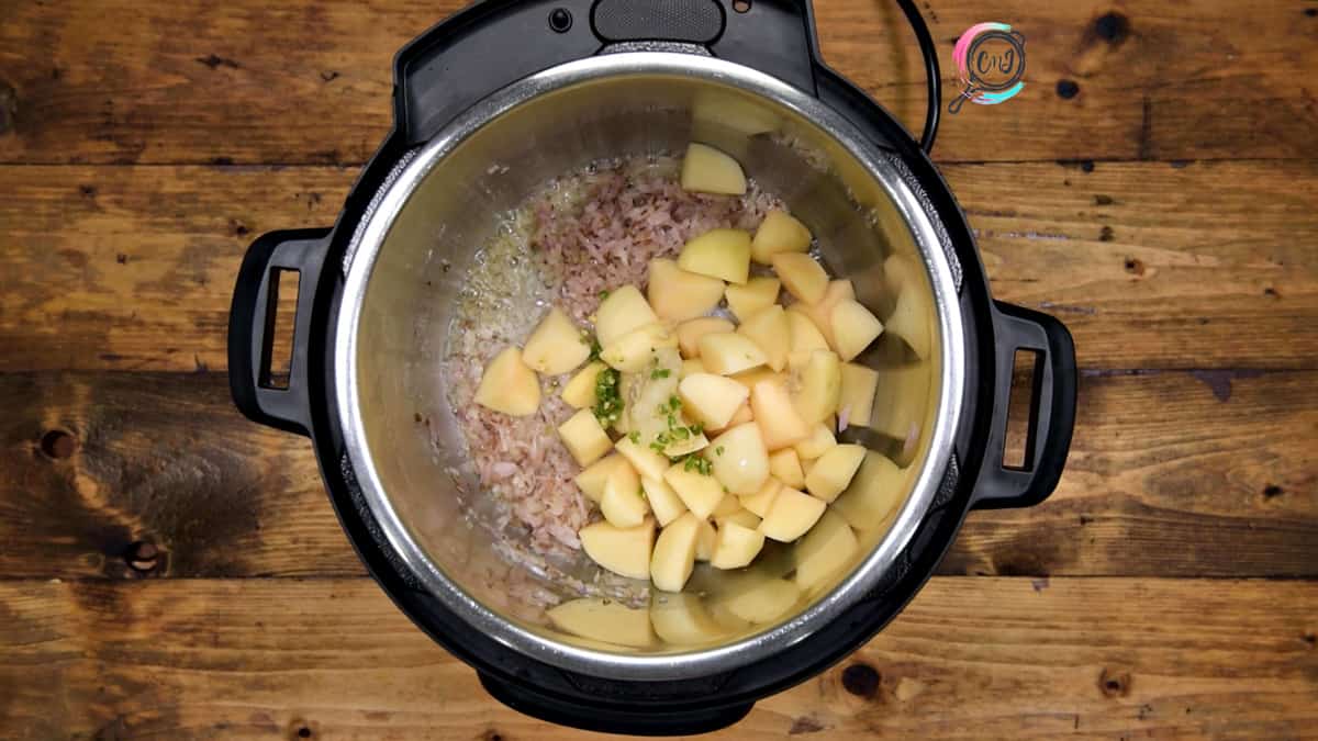 Potato cubes, ginger garlic paste and green chilies added in pot.