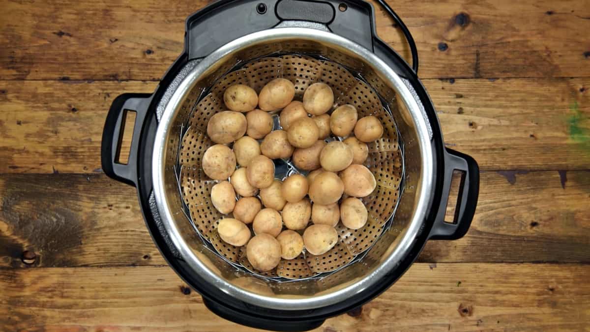 Baby potatoes added in steamer basket placed in the steel insert of Instant Pot.