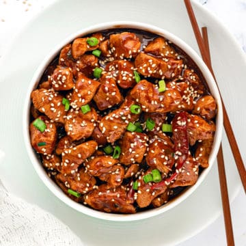 Instant Pot General Tso Chicken gravy served in white bowl with a pair of chopsticks.