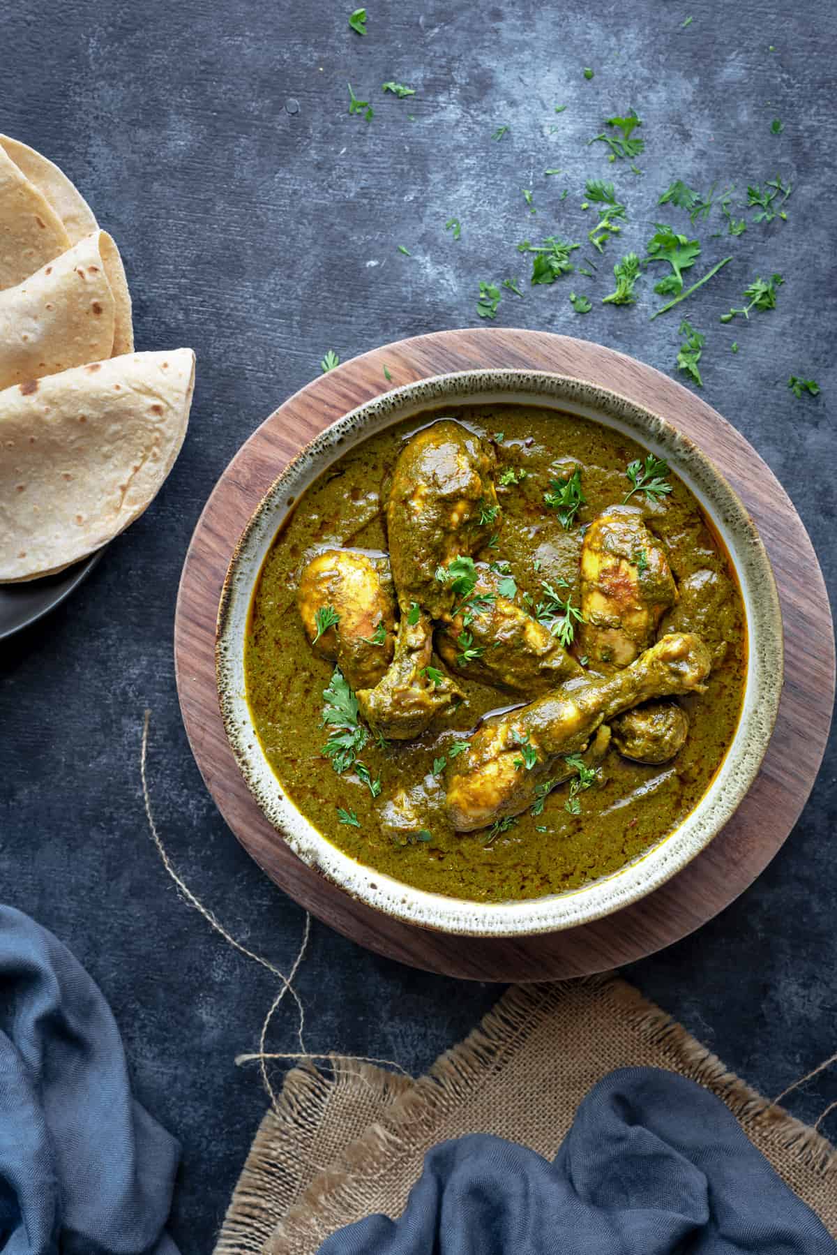 Chicken Saagwala curry served in a bowl with Indian roti bread on the side.