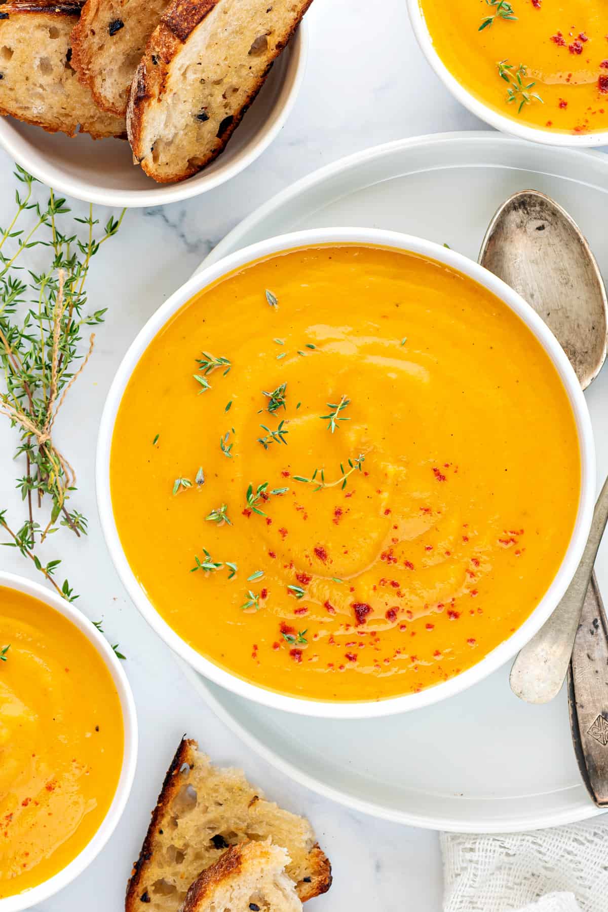 Close up shot of curried instant pot butternut squash soup in white bowl with toasted bread.