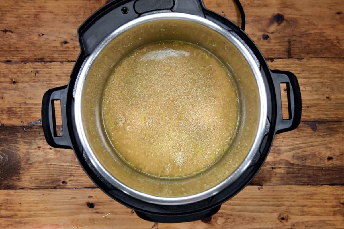 Vegetable broth added to the quinoa in pot.