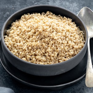 Close up shot of cooked quinoa in black bowl.