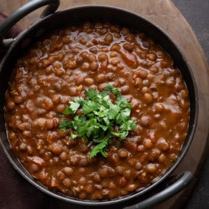 Whole Masoor Dal Lentil Curry garnished with cilantro in Indian wok kadai.