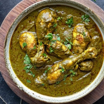 Chicken saag curry served in a grey ceramic bowl.