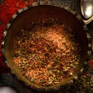 Close up shot of cajun seasoning in brass bowl.