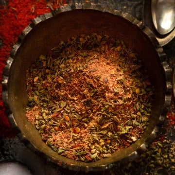 Close up shot of cajun seasoning in brass bowl.
