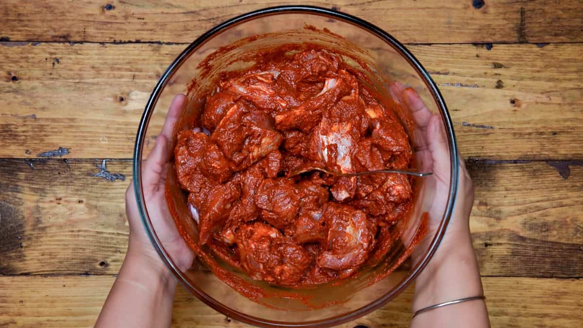 Lamb mixed with vindaloo paste is ready for marination.