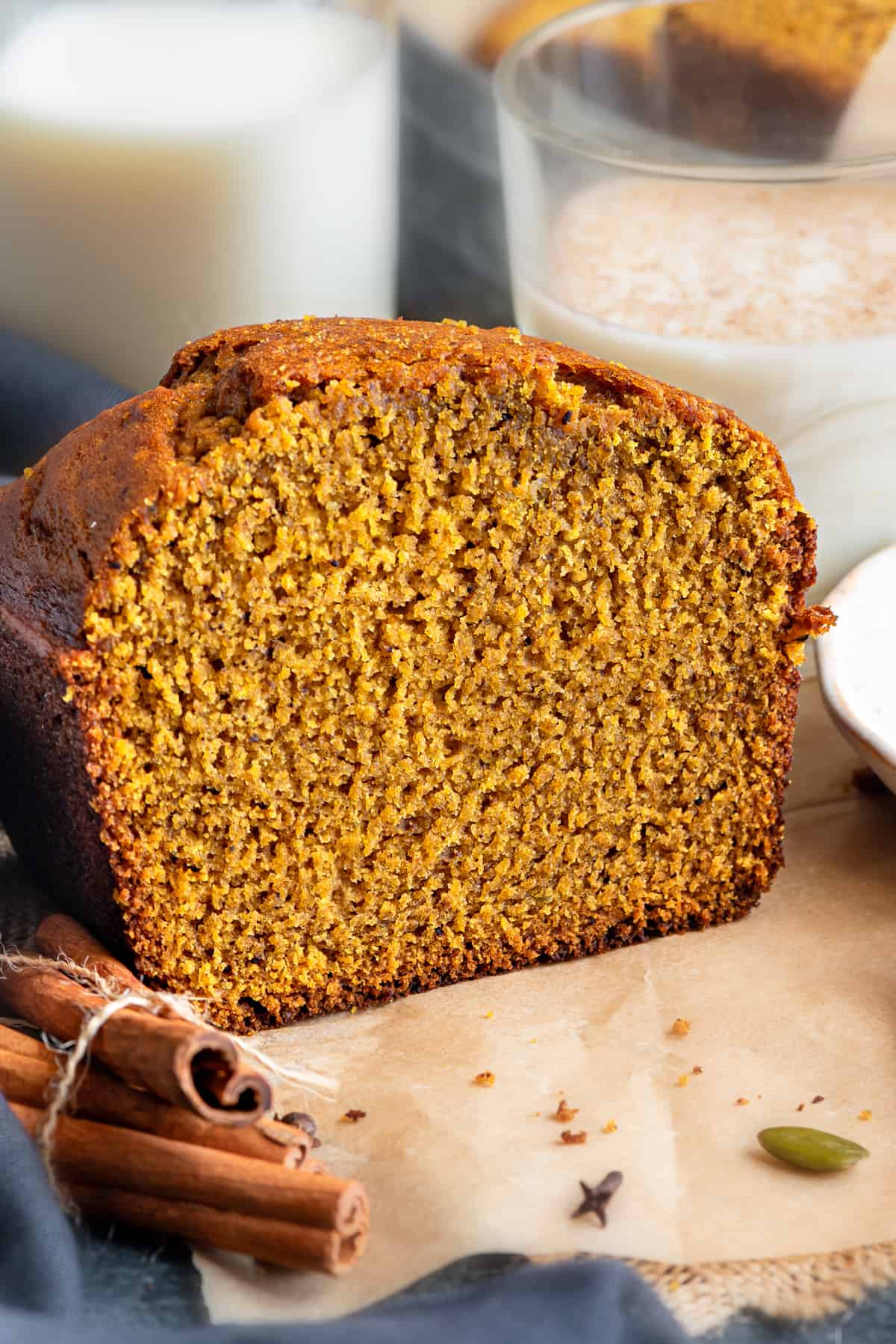 Closeup of Pumpkin Bread cut slice showing texture and milk glass at the back.