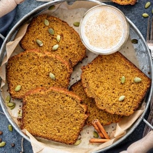 5 slices of pumpkin bread placed on round tray with glass of milk on side.