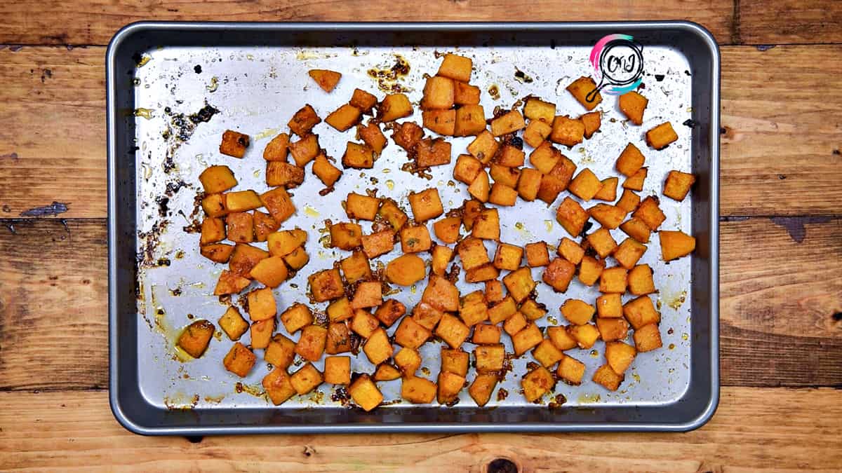 Savory roasted butternut squash cubes in baking sheet pan.