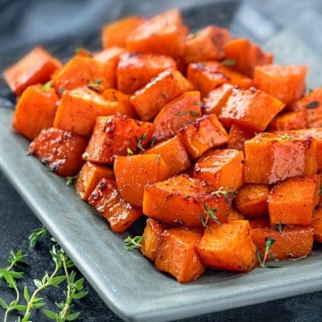 Close up of roasted sweet potatoes served in blue plate.