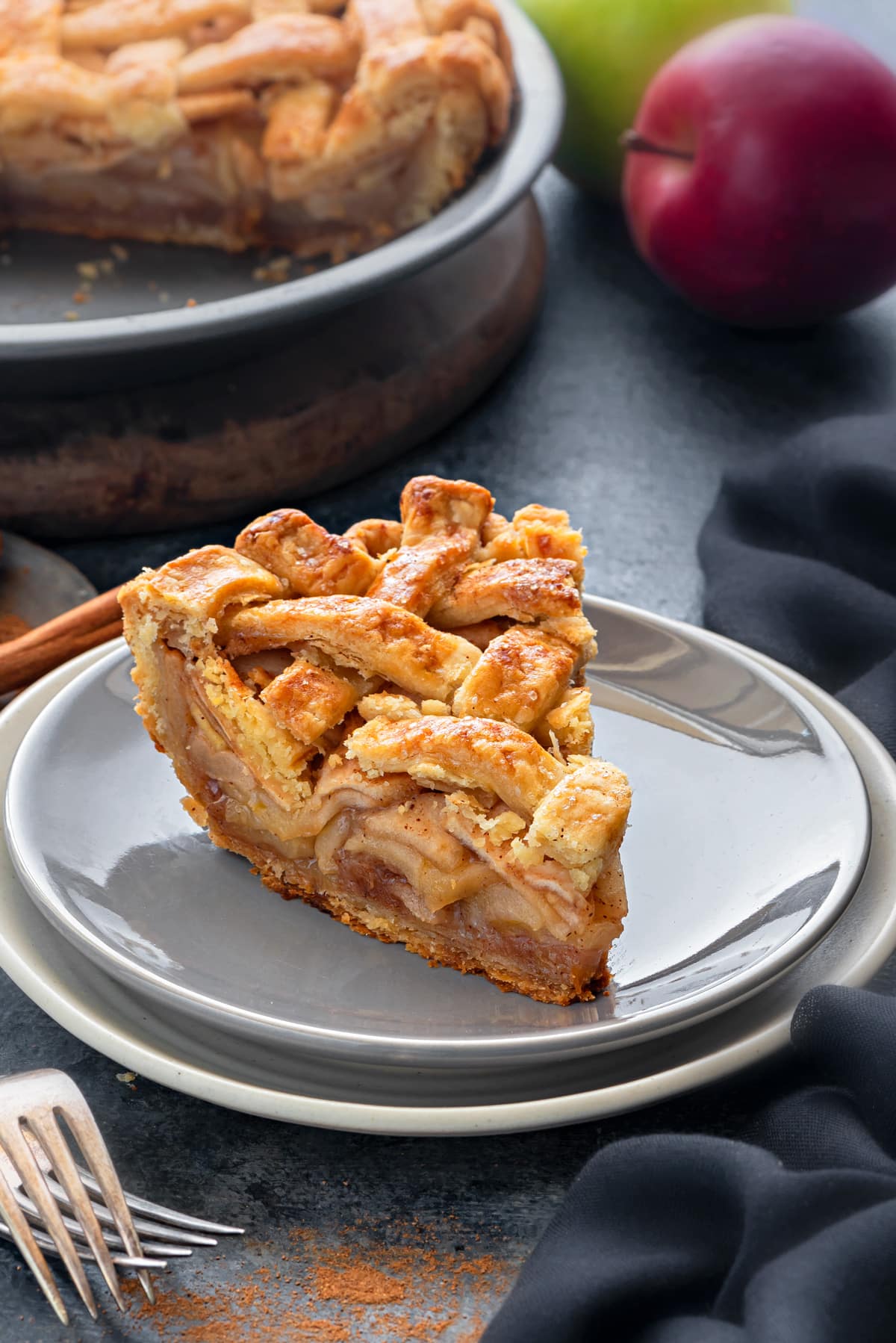 A thick slice of homemade apple pie, with a golden brown lattice top.