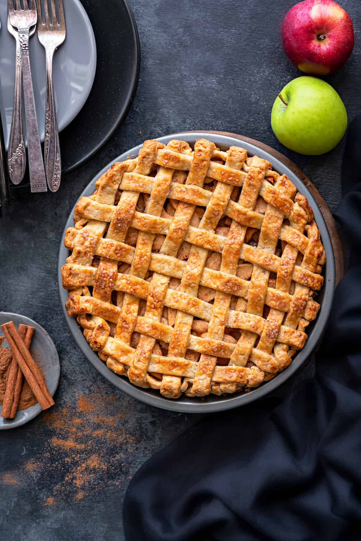 Overhead shot of a large apple pie with a woven-looking crust in a dish.