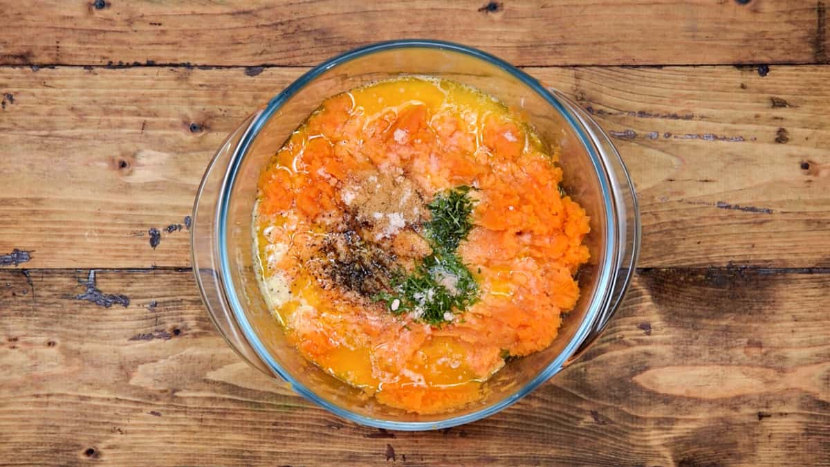 Melted butter, milk and seasonings added to mashed sweet potato placed in glass bowl