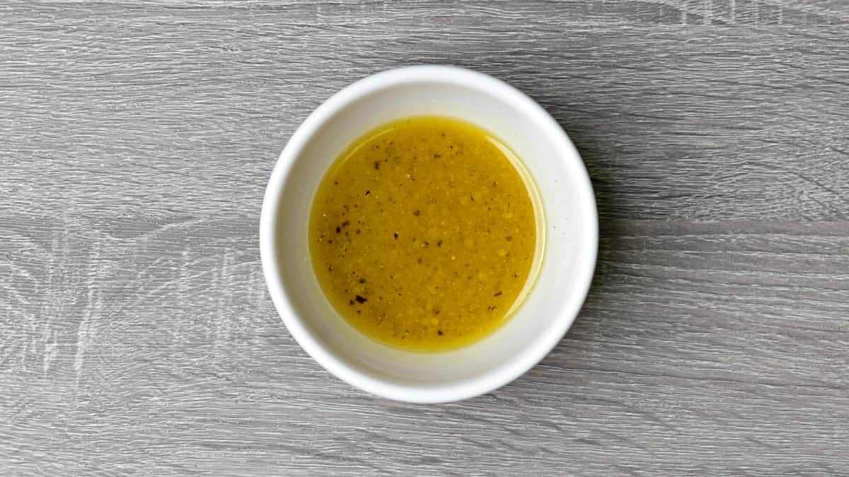apple cider vinaigrette after whisking in a small white bowl