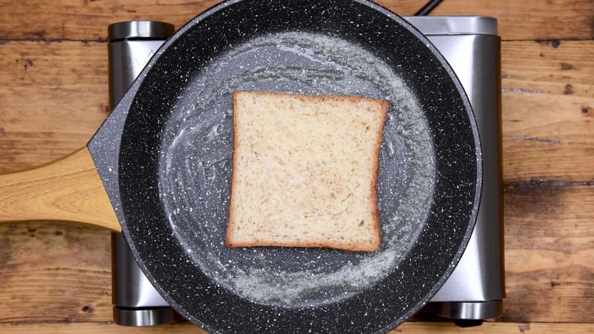 custard soaked bread added to a skillet with butter