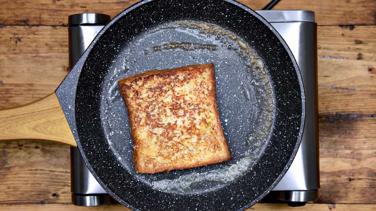 slice of french toast after being flipped in pan