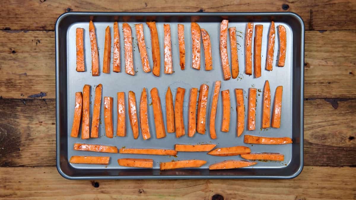 uncooked sweet potato fries on a sheet pan