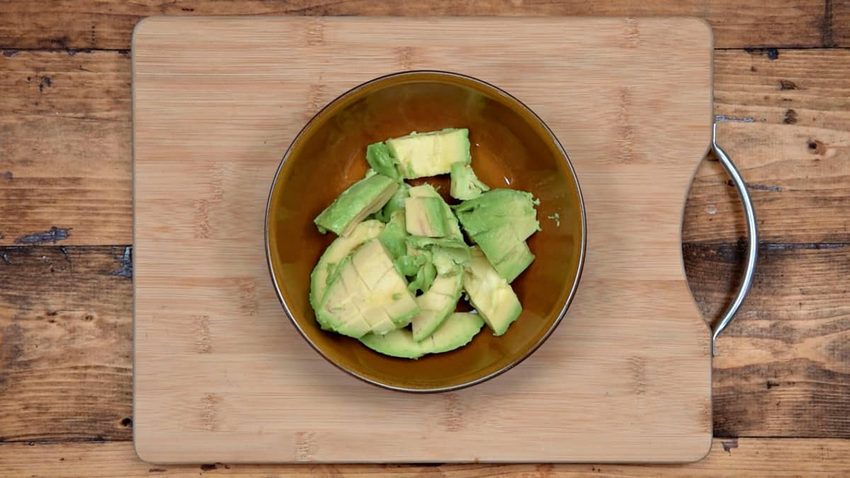 cubed avocado in a bowl on a cutting board