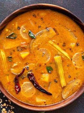 close up shot of vegetable sambar dal in wooden bowl.