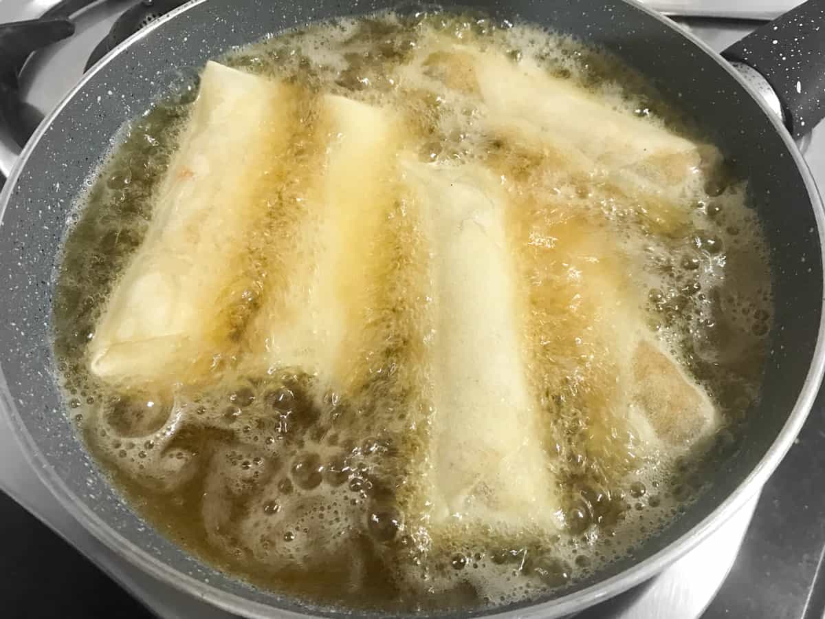 Deep frying spring rolls in hot oil in wok