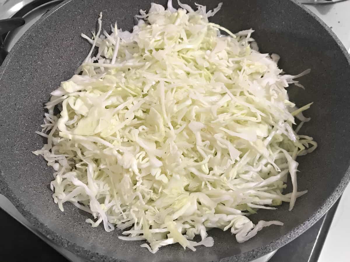 cabbage added to allium mixture in wok