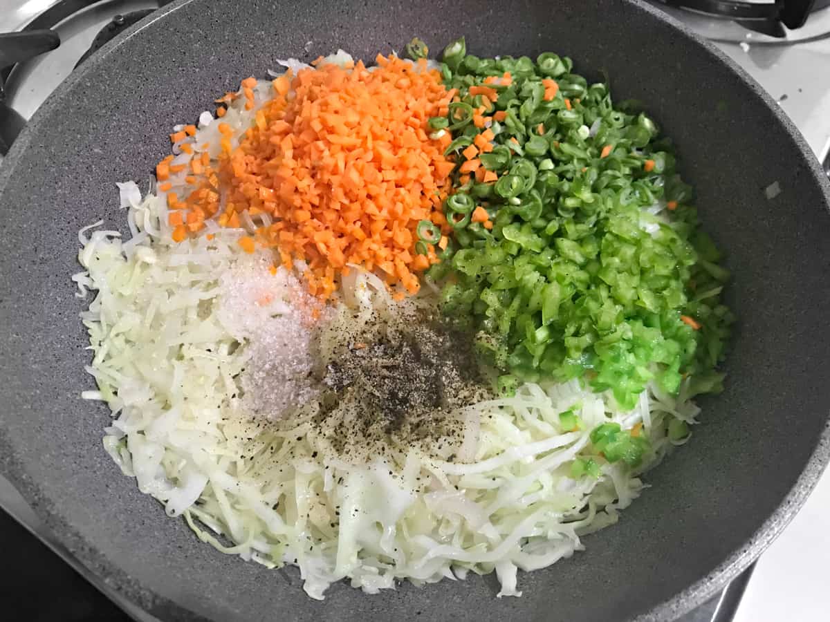 carrots, green beans, green bell peppers, salt and pepper added to wok with cabbage and alliums