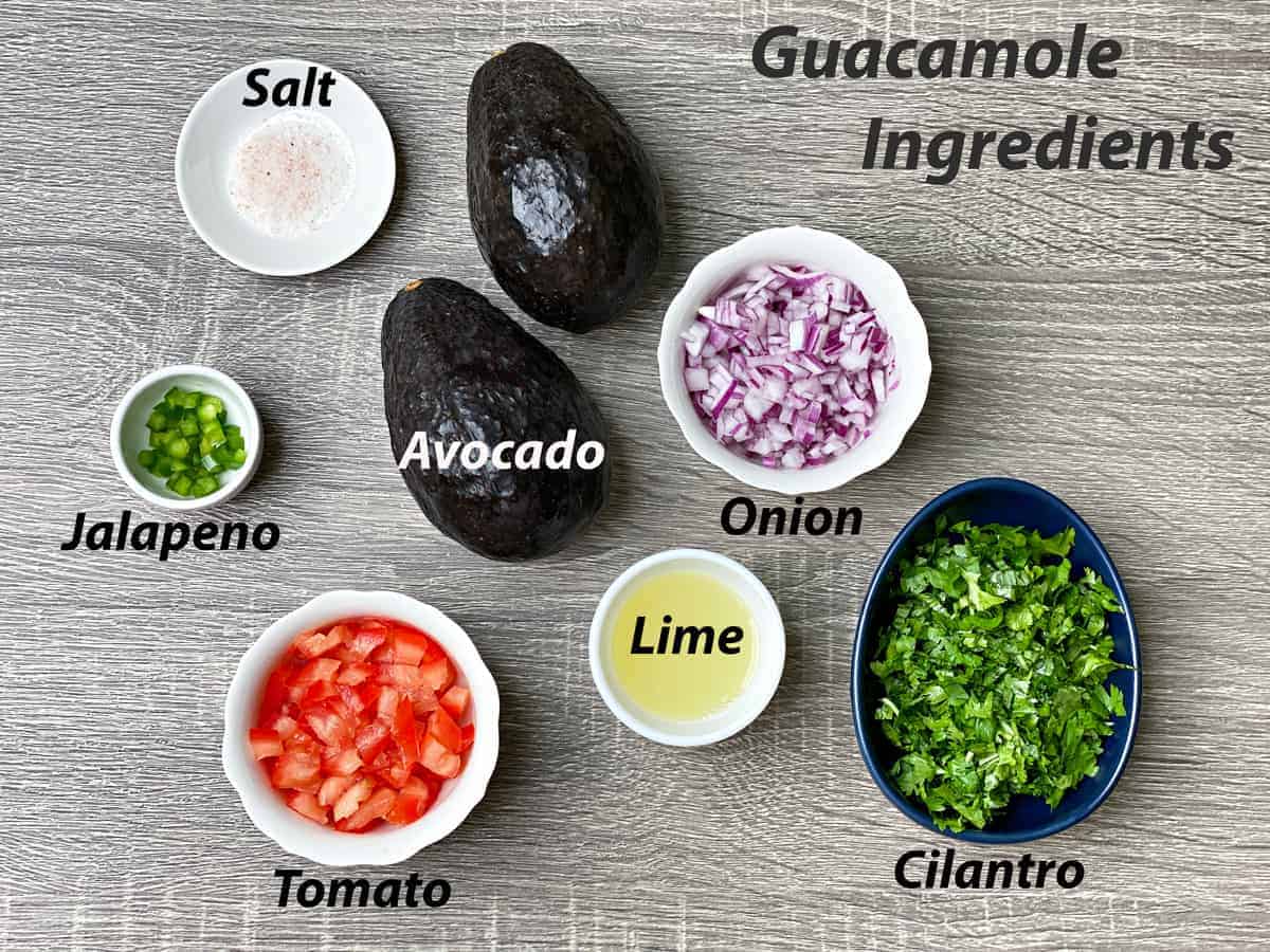 mise en place for simple guacamole recipe - salt, jalapeño, avocado, onion, cilantro, tomato and lime juice