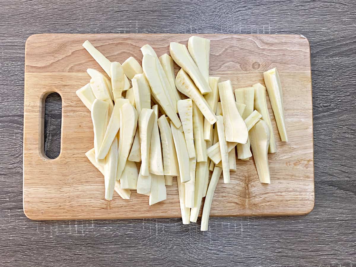 parsnips cut into batons on a wooden cutting board