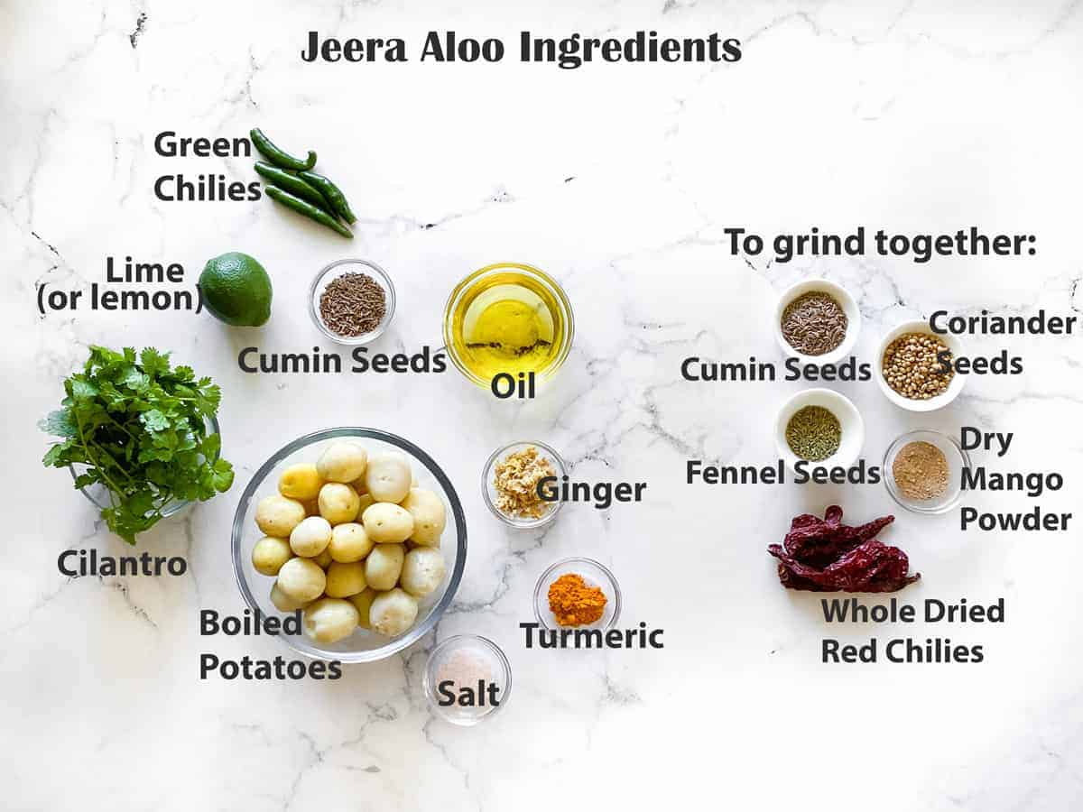 mise en place for jeera aloo recipe - boiled baby potatoes, spices, seasonings, lime, chilies and cilantro