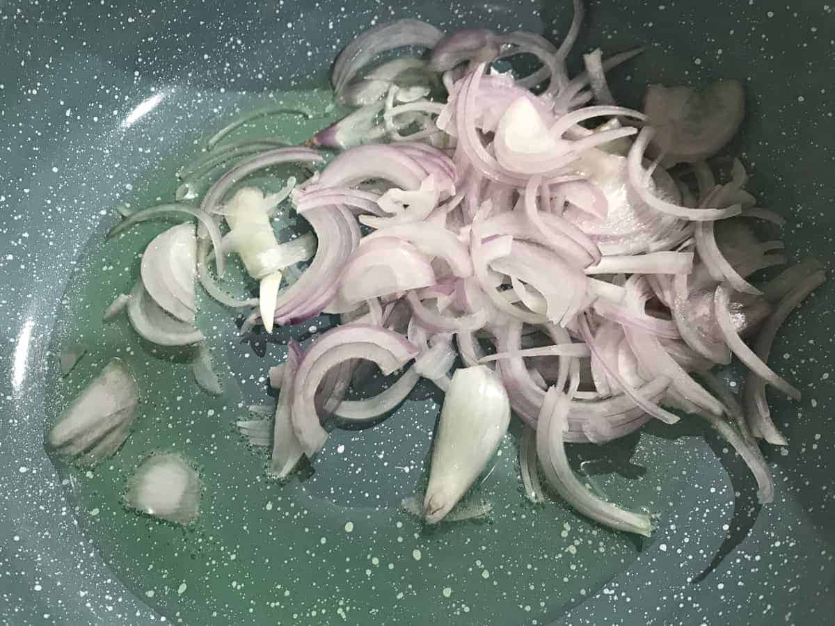 onions frying in oil in pan