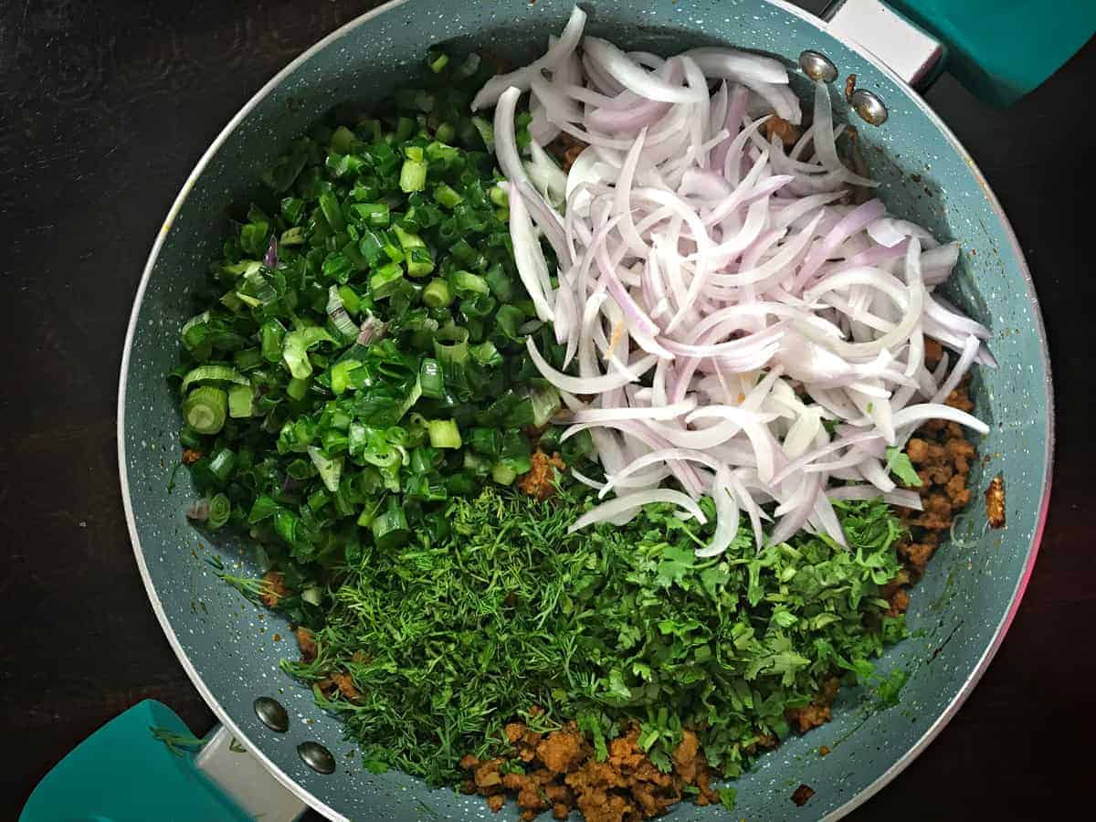 fresh onions, dill, cilantro and spring onion greens added to keema samosa meat mixture