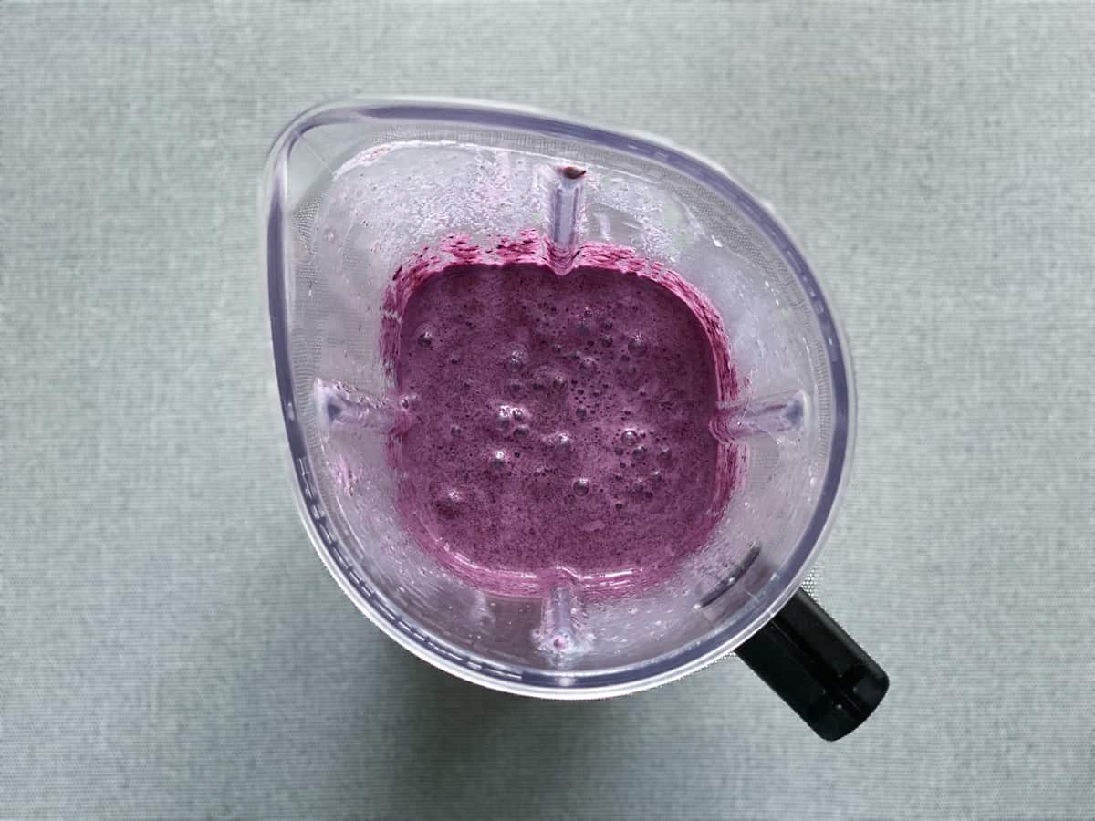 vegan blueberry almond milk smoothie after being blended in a blender