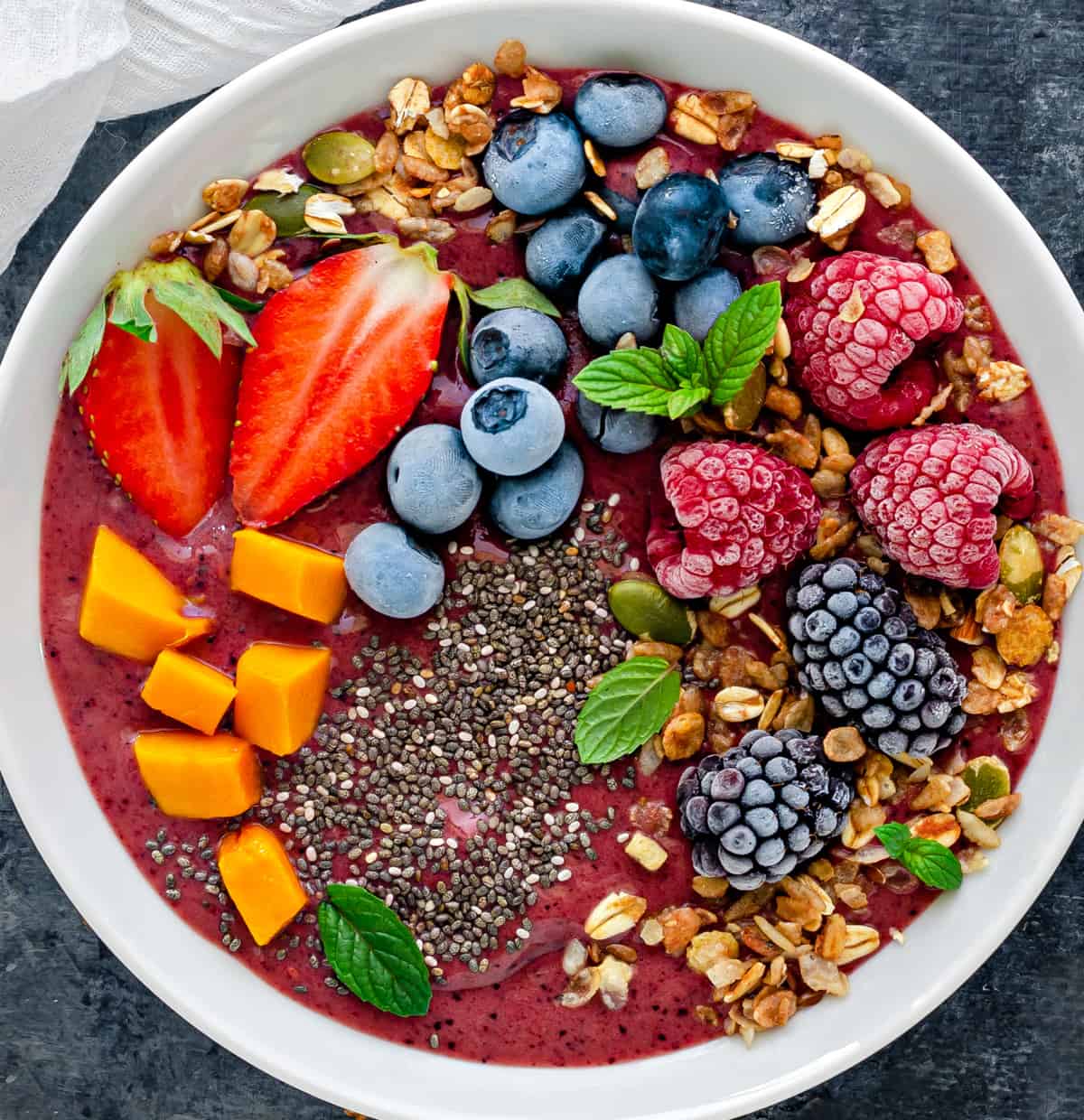 close up shot of a frozen fruit smoothie bowl with an assortment of toppings