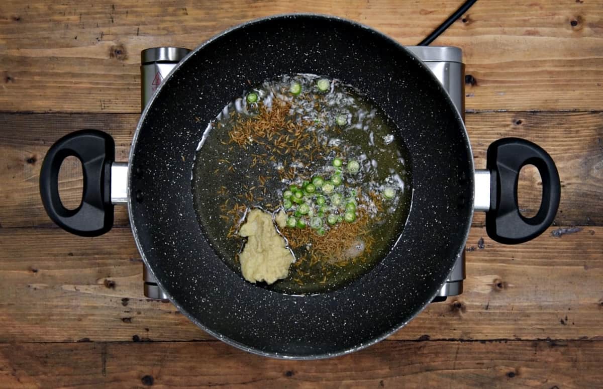 cumin, chopped chilies and ginger garlic paste added into the heated oil and butter in pan