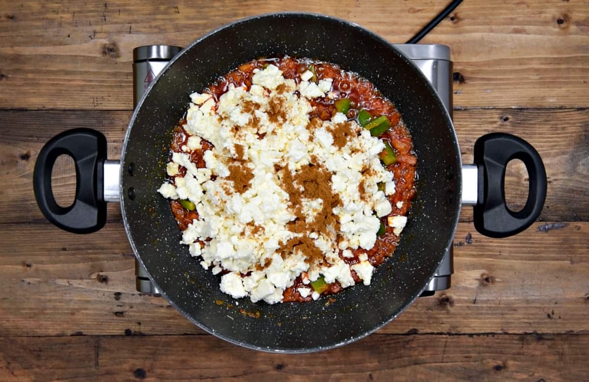 crumbled paneer and garam masala powder added to onion tomato masala in pan