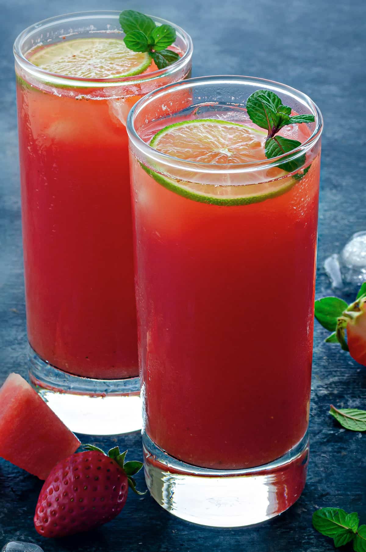 two tall collins glasses filled with watermelon strawberry lemonade