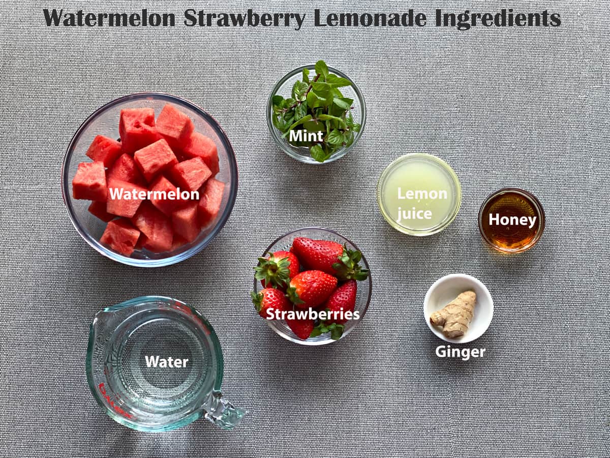 ingredients to make watermelon strawberry lemonade in small dishes laid out on a grey table