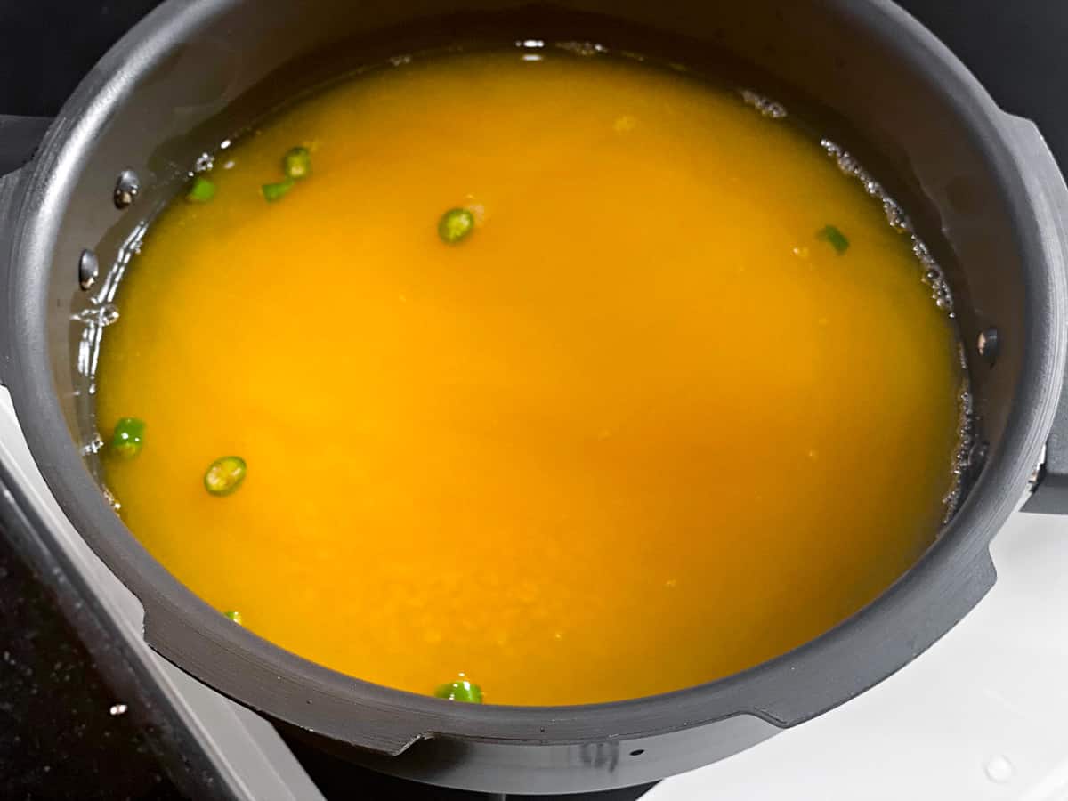 yellow lentils, turmeric, green chilli salt, and water added to a pressure cooker.