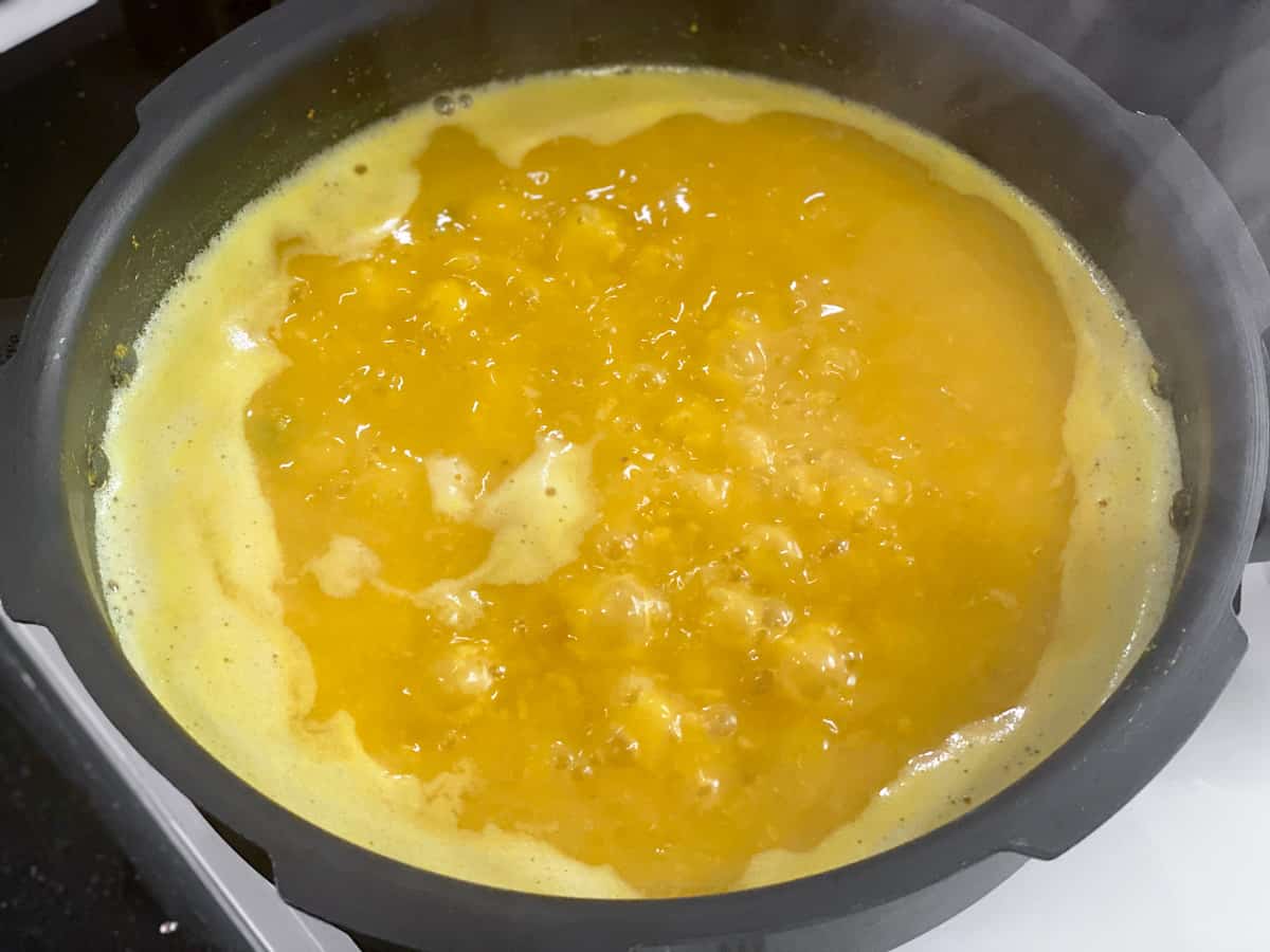 The boiled dal is simmering in pressure cooker.