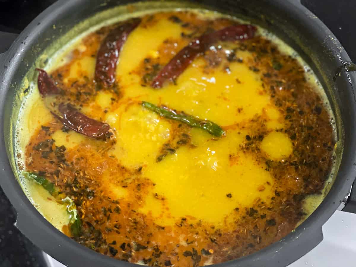 Tempering( tadka) and lemon juice added to the boiling dal.