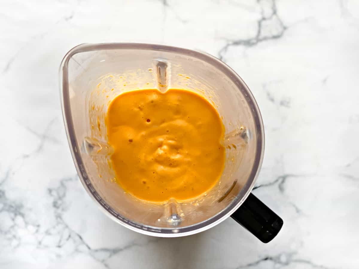 overhead shot of blender pitcher filled with frozen mango oat smoothie