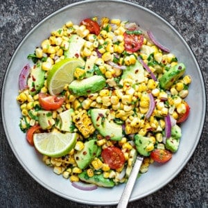 Close up shot of corn avocado salad served in ceramic bowl