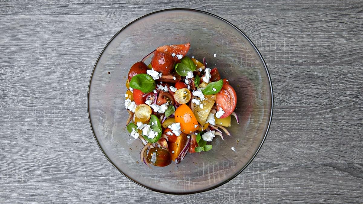 basil and feta added to tomato salad after resting for 15 minutes